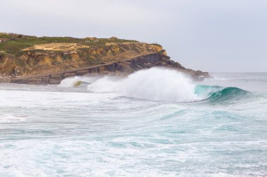 Okyanus kıyısı, köpüklü hareketli dalgalar. 