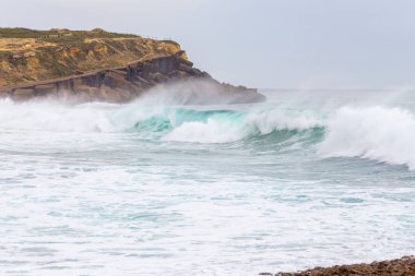 Okyanus kıyısı, köpüklü hareketli dalgalar. 