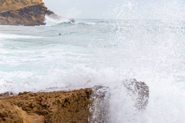 Okyanus kıyısı, köpüklü hareketli dalgalar. 