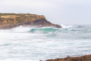 Okyanus kıyısı, köpüklü hareketli dalgalar. 