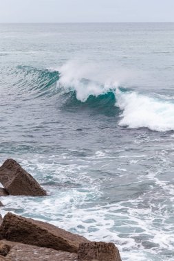 Okyanus kıyısı, köpüklü hareketli dalgalar. 