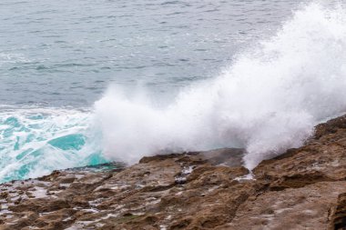 Okyanus kıyısı, köpüklü hareketli dalgalar. 