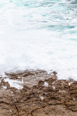 Okyanus kıyısı, köpüklü hareketli dalgalar. 