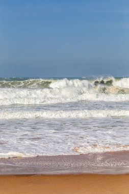 Okyanus kıyısı, köpüklü hareketli dalgalar. Rüzgar gücü. Turkuaz su. 