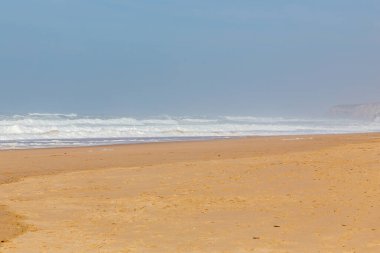 Okyanus kıyısı, köpüklü hareketli dalgalar. Rüzgar gücü. Turkuaz su. 
