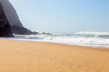 Okyanus kıyısı, köpüklü hareketli dalgalar. Rüzgar gücü. Turkuaz su. 