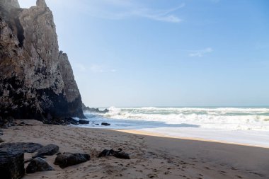 Okyanus kıyısı, köpüklü hareketli dalgalar. Rüzgar gücü. Turkuaz su. 
