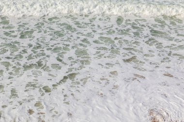 Okyanus kıyısı, köpüklü hareketli dalgalar. Rüzgar gücü. Turkuaz su. 