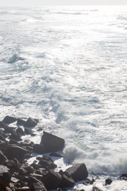 Okyanus kıyısı, köpüklü hareketli dalgalar. Rüzgar gücü. Turkuaz su. 