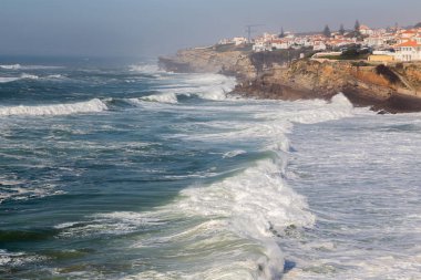 Okyanus kıyısında sahil, köpüklü hareketli dalgalar. Praia de Maca, Sintra, Portekiz