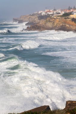 Okyanus kıyısında sahil, köpüklü hareketli dalgalar. Praia de Maca, Sintra, Portekiz