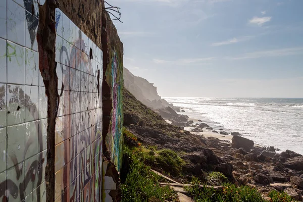 Abadoned wall on ocean coast, view on water. Wind power. Turquoise water.