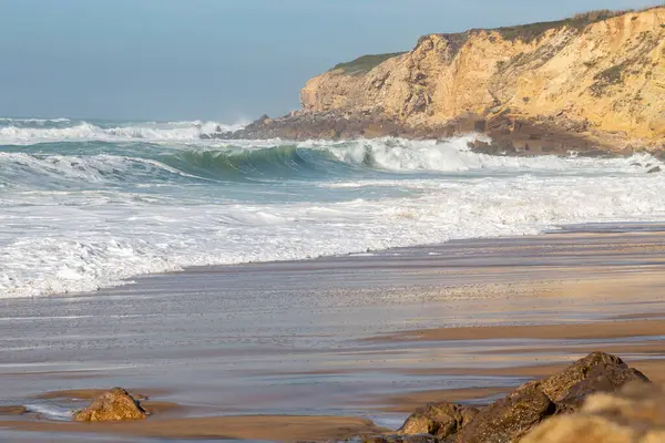 Okyanus kıyısı, köpüklü hareketli dalgalar. Rüzgar gücü. Turkuaz su. 