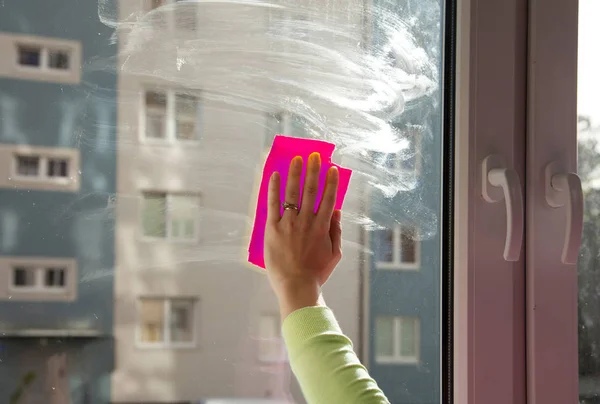Женская рука моет окно — стоковое фото