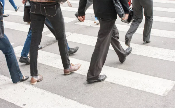 Pernas de pedestres em uma passadeira — Fotografia de Stock