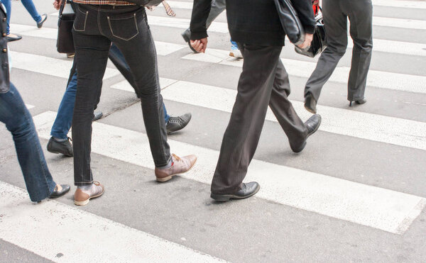 legs of pedestrians in a crosswalk