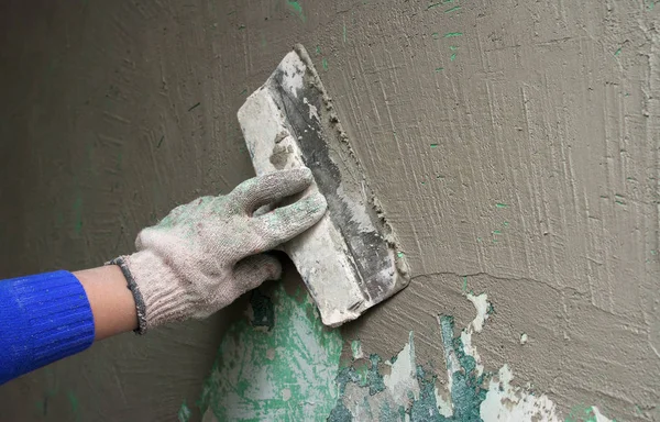 Рука с лопатой штукатурки стены — стоковое фото