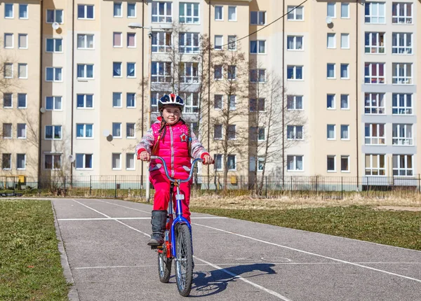 Niña en un casco de seguridad en bicicleta —  Fotos de Stock