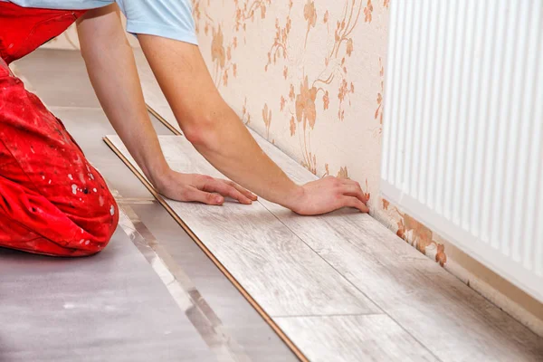 Manitas jóvenes instalando piso de madera — Foto de Stock