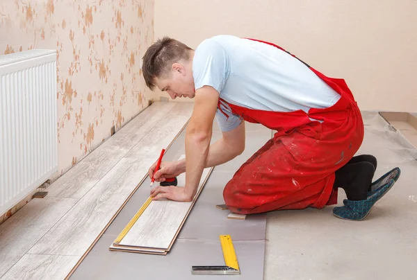 El hombre que pone suelo laminado — Foto de Stock