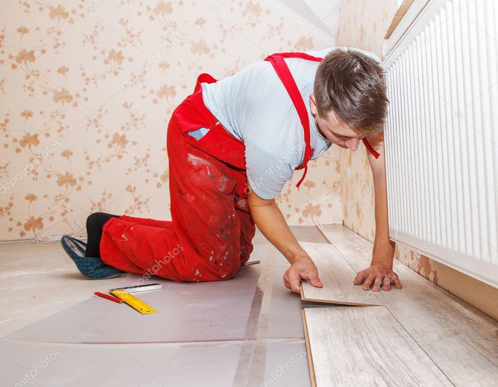 young handyman installing wooden floor