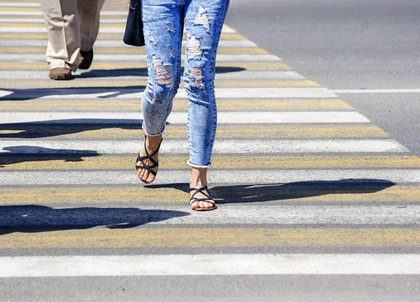 Jeune femme traversant une rue de la ville — Photo