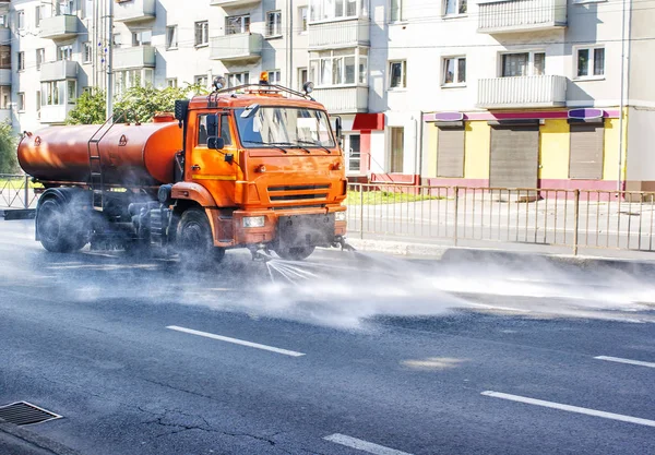 Limpieza de la máquina de lavado de la ciudad asfalto carretera con spray de agua —  Fotos de Stock