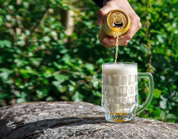 Homem derramando cerveja de um frasco em uma caneca — Fotografia de Stock