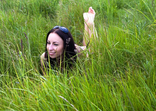 Mladá žena ležící na trávě — Stock fotografie