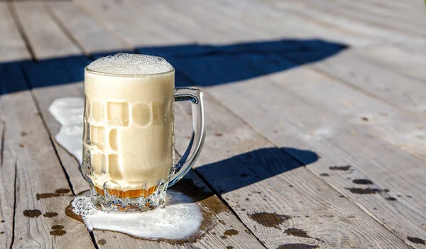 Tazza di vetro con birra sul tavolo nel parco — Foto Stock