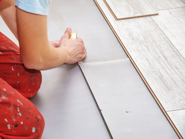 Las manos del manitas que ponen las tablas laminadas del suelo — Foto de Stock