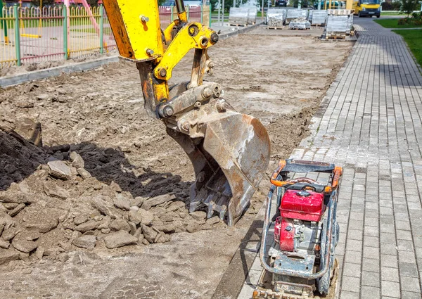 Construcción de una nueva carretera. excavadora prepara la superficie —  Fotos de Stock