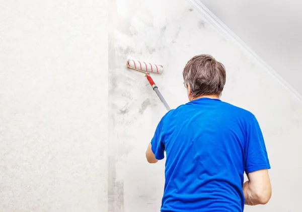 Pared de pintura de trabajador con pegamento de fondo para un fondo de pantalla — Foto de Stock