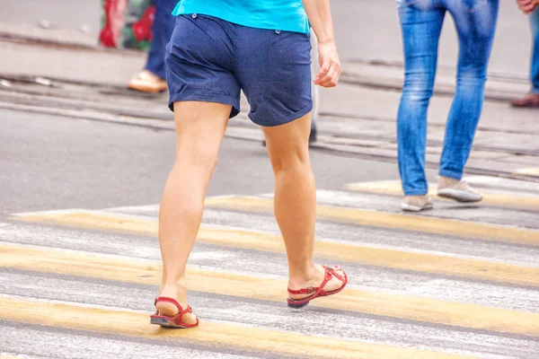 年轻女人的脚，穿越城市的街道 — 图库照片