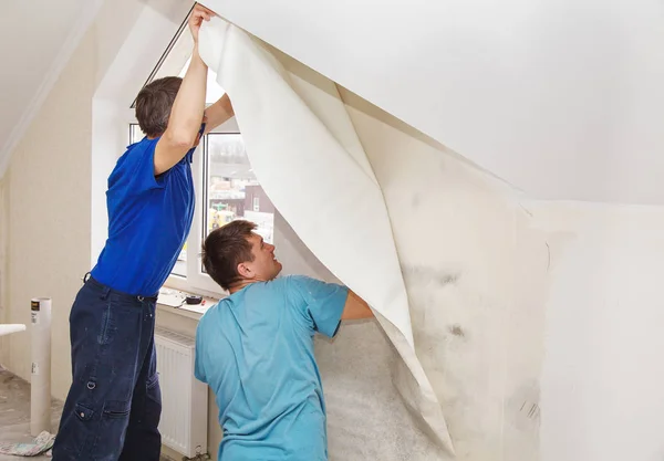 Two workers smoothing wallpaper — Stock Photo, Image