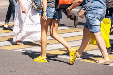 Güneşli bir yaz gününde yaya geçidinde karşıya geçen yayalar.