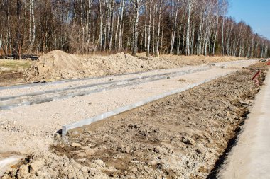 Güneşli bahar gününde ormanda yeni bir modern yol inşaatı