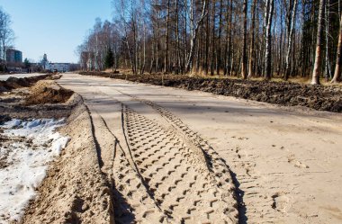Güneşli bahar gününde ormanda yeni bir modern yol inşaatı