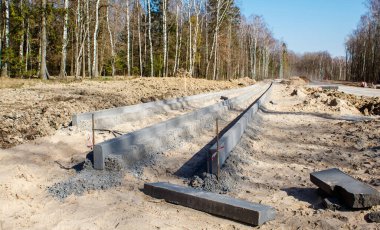 Güneşli bahar gününde ormanda yeni bir modern yol inşaatı