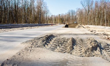 Güneşli bahar gününde ormanda yeni bir modern yol inşaatı