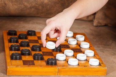 Anne ve kızı evde dama oynuyorlar. Coronavirus karantinası. el yakın çekim