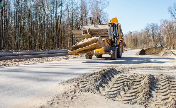 晴れた春の日に森の中に新しい近代的な道路を建設し — ストック写真