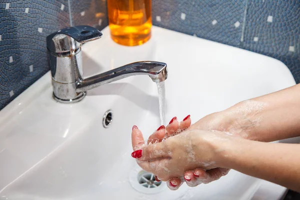 woman washes hands with soap in a washroom. coronavirus quarantine. hands closeup