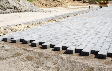 Güneşli bir günde, açık havada fayanslardan yapılmış yeni bir kaldırım inşaatı