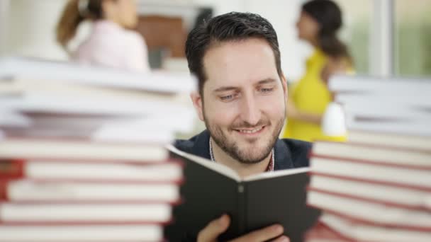 Estudiante estudiando con montones de libros — Vídeo de stock