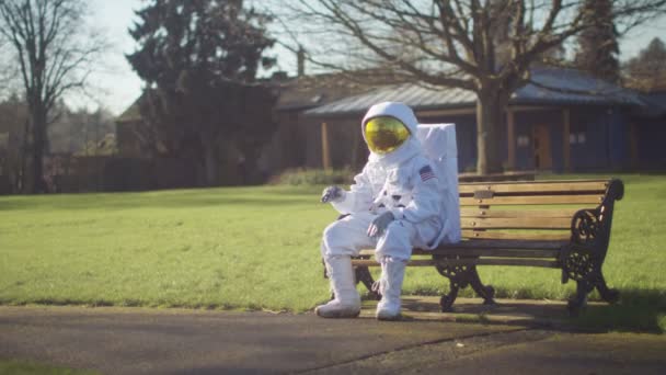 Astronaut lost in a park — Stockvideo