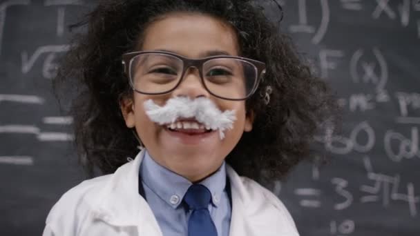 Scientist standing near math formulas on blackboard — Stock Video