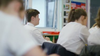 Öğretmenleri dinleyen öğrenciler.