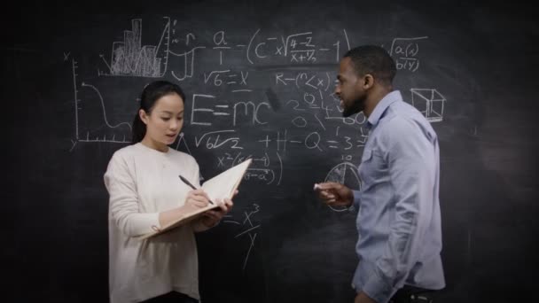 Man and woman writing math formulas — Stock Video