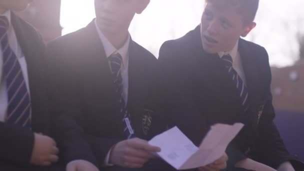 Мальчики смотрят на лист бумаги — стоковое видео